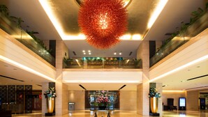 A spacious lobby with a central reception desk, a large decorative chandelier, and potted plants. - Rivan Hotel Longgang Shenzhen (Shenzhen)