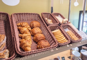 Wicker baskets filled with various breads and pastries on display. - B&B Hotel Limoges 1 (Limoges)