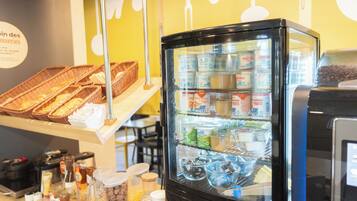 Un refrigerador exhibe diferentes productos alimenticios y un mostrador con cestas y aderezos.