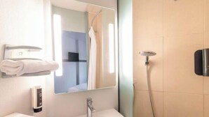 Ein modernes Badezimmer mit Waschbecken, Spiegel, Handtuchhalter und Duschbrause.
