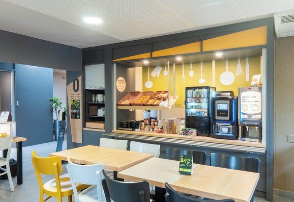 A restaurant with a counter, seating area, and various food items displayed. - B&B Hotel Limoges 1 (Limoges)