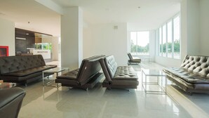 A spacious, modern living area with leather sofas and a glass coffee table.