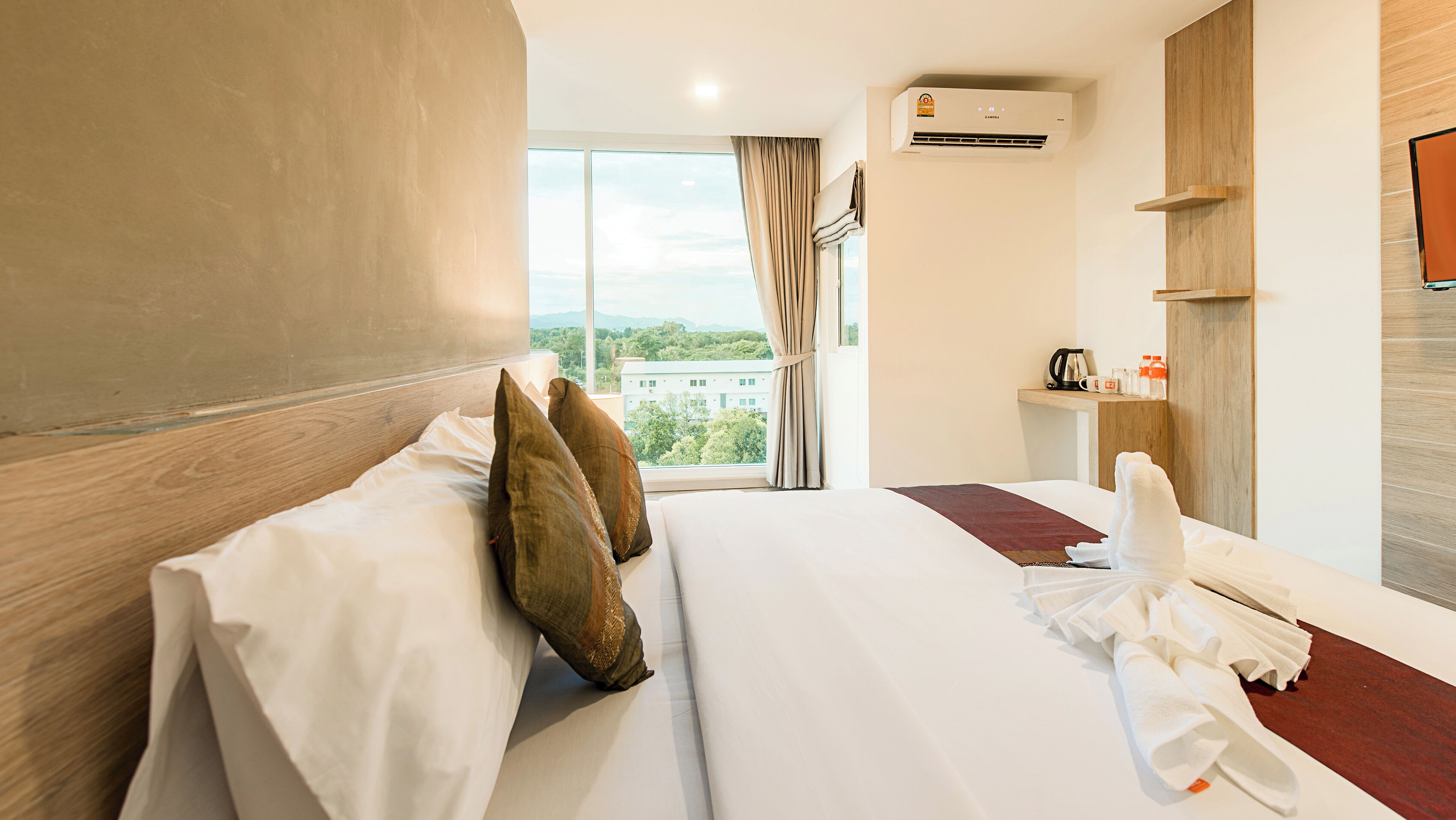 Habitación de hotel con una cama grande, vista a la ciudad y una cafetera en la mesita de noche.