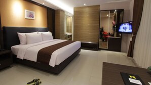 Een moderne hotelkamer met een groot bed, een bureau, een televisie en een spiegel.
