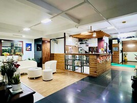 Un interior moderno con mostrador de recepción, zona de estar y una encimera de madera.