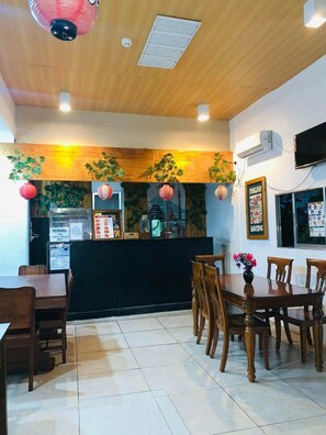A restaurant interior with wooden ceiling, tiled floor, and a counter with menu boards. - Axis Pension Hotel (Lapu-Lapu)