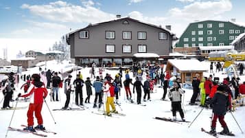 A ski resort with a large building in the center, surrounded by snow-covered terrain and other buildings.