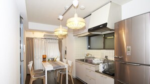 Una cocina compacta con comedor, electrodomésticos de acero inoxidable e iluminación colgante.