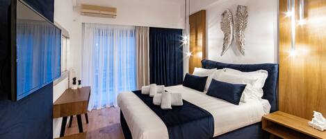 Una habitación de hotel moderna con una cama grande, una mesita de noche de madera, un espejo y un adorno en la pared.