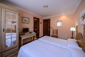 A bedroom with a bed, a desk, a chair, and a wardrobe. - Hotel Rio Cea (Valderrueda)