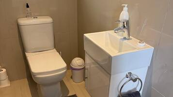 Ein modernes Badezimmer mit Toilette, Waschbecken und Handtuchhalter.