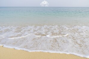 Una playa con agua cristalina y olas suaves.