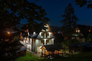 A large, multi-story house with a well-lit exterior and a covered outdoor area. - U Gałów Poronin (Poronin)