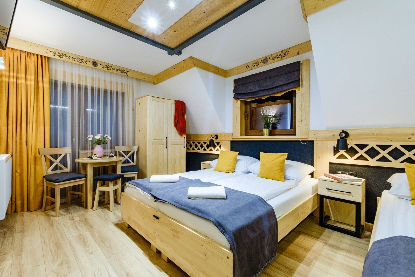 A bedroom with a wooden bed, a desk, and a chair.