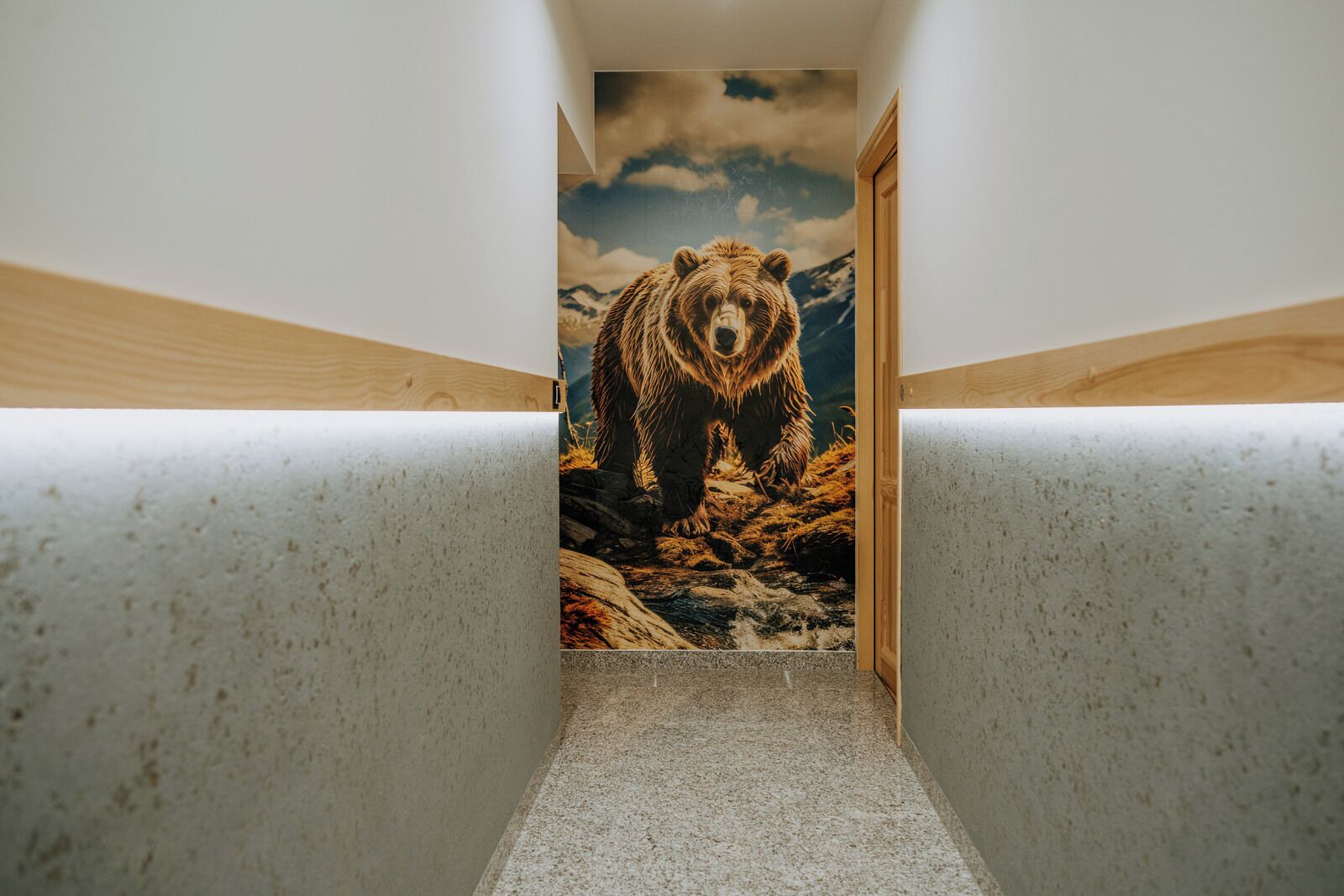 A narrow hallway with a bear mural on the wall.