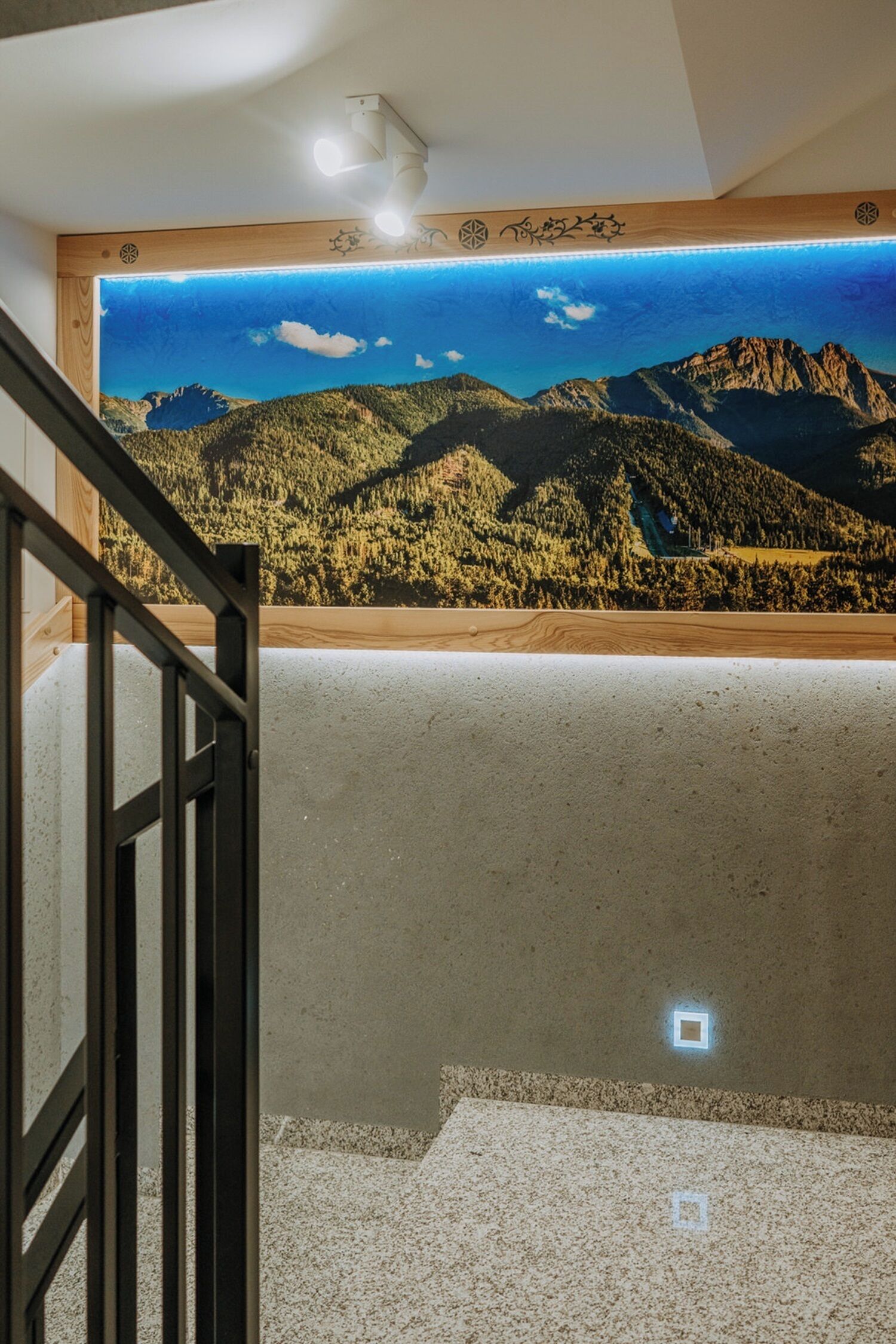Una escalera con vistas a un paisaje montañoso a través de un ventanal amplio.