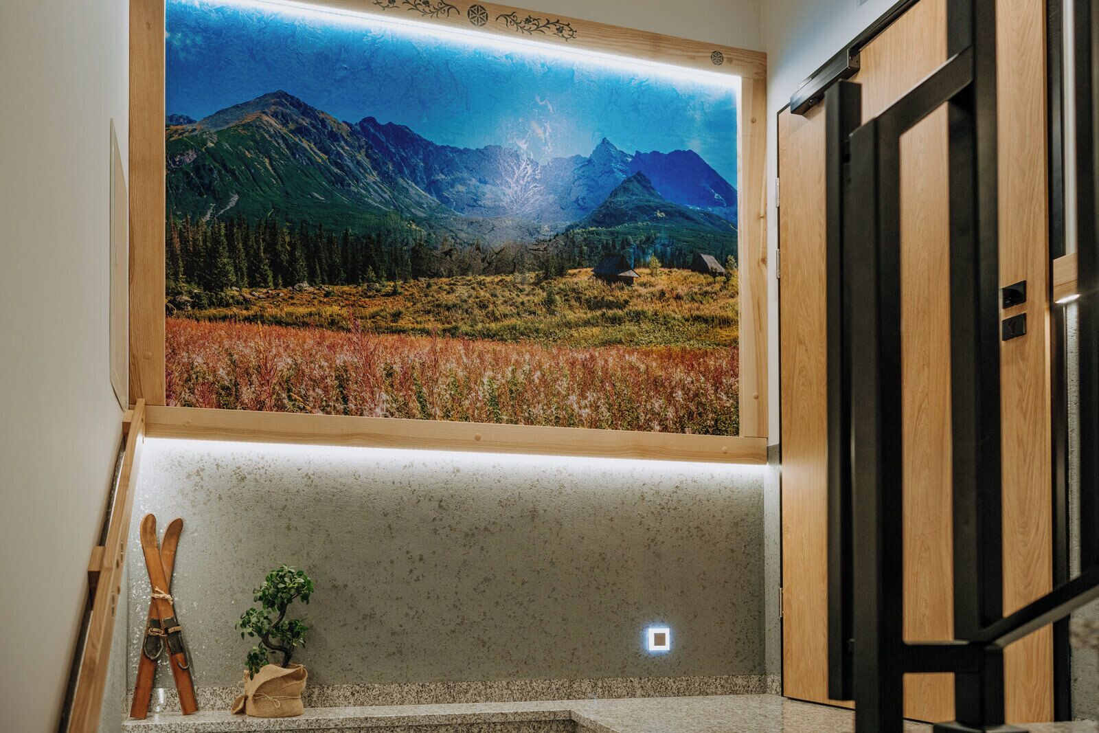A room with a large window displaying a mountainous landscape.