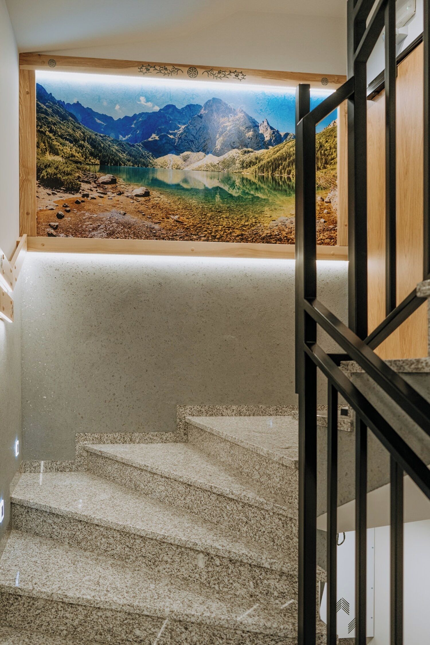 A staircase with a view of a mountainous landscape through a window.