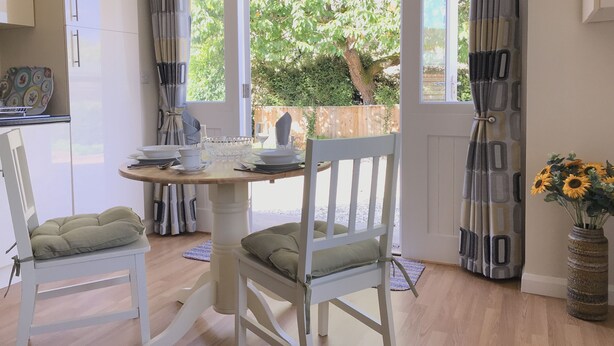 A dining area with a table, chairs, and a view of the outdoors. - Cherry Tree Cottage (Chipping Norton)