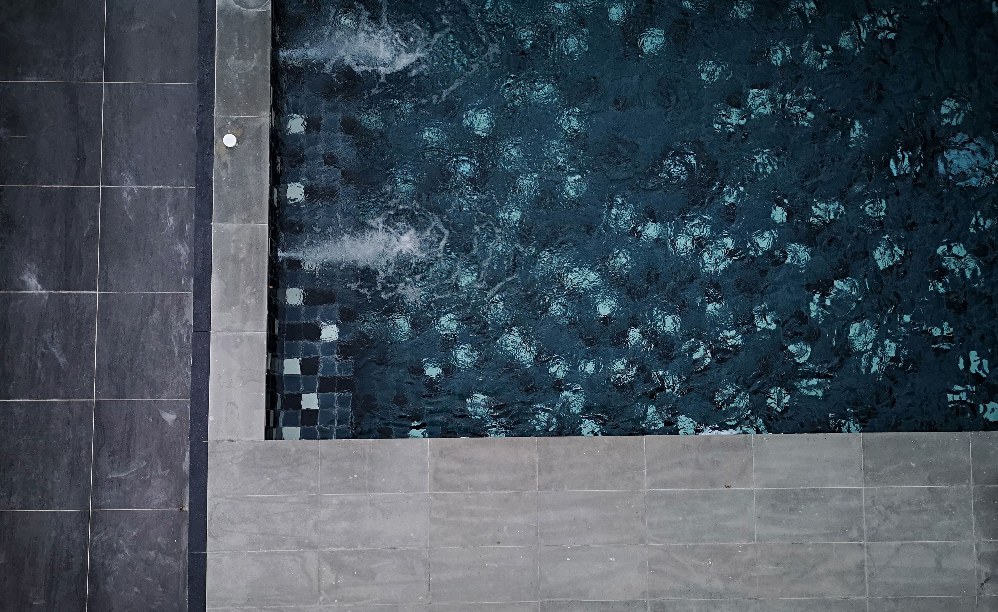 A rectangular pool with a dark, textured surface and a tiled border.