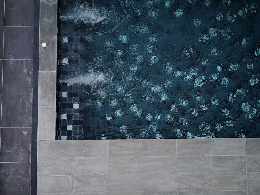 A rectangular pool with a dark, textured surface and a tiled border.
