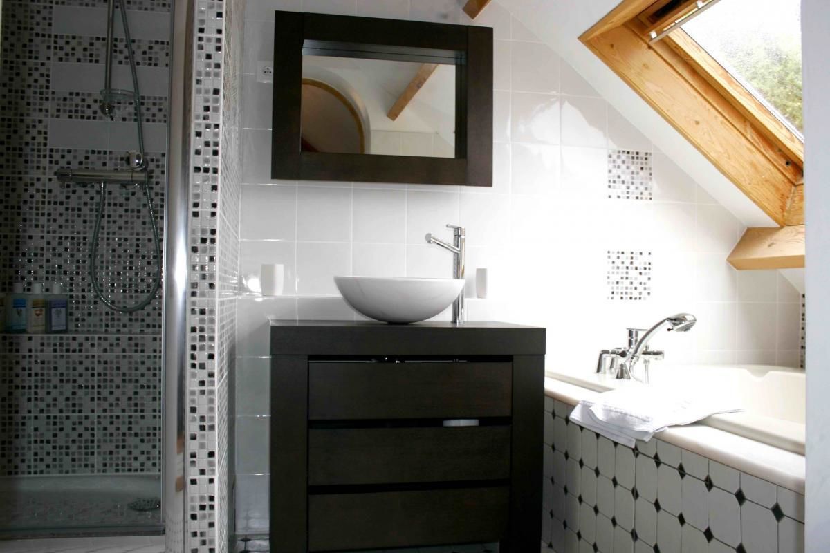 Une salle de bain moderne avec un grand miroir, un lavabo sur colonne et une douche aux carreaux de mosaïque.