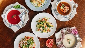A table with various dishes including soup, salad, and seafood.