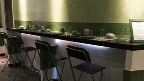 Una zona de bar con barra, sillas y una pizarra de menú.