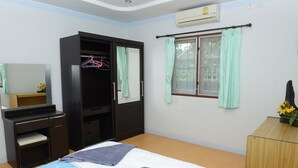 Une chambre à coucher avec un lit, une armoire, un bureau et une fenêtre avec des rideaux.