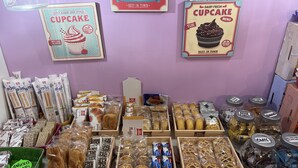 Una vitrina de panadería con diversos productos horneados y pasteles.