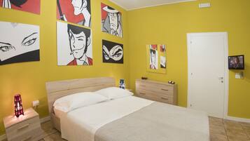 Un dormitorio con cama, mesita de noche, cómoda y una pared decorada con ilustraciones tipo cómic.