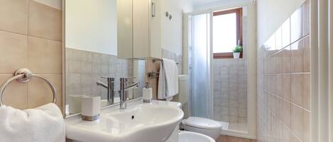 A modern bathroom with a sink, toilet, and shower.