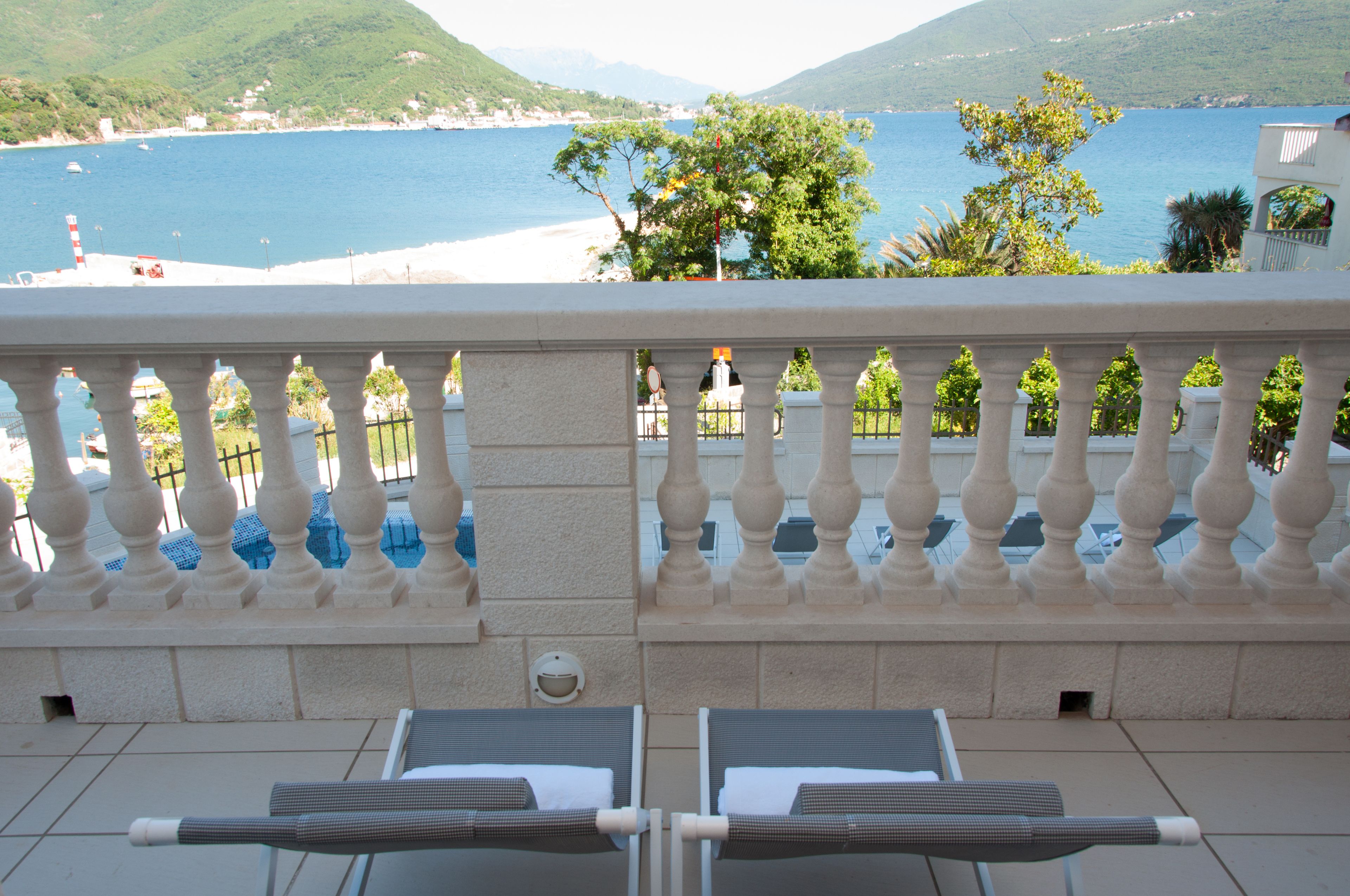 A balcony with two sun loungers facing a coastal view.