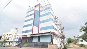 A multi-story building with a modern design, featuring a prominent vertical red stripe and blue-tinted windows. - JK Residency (Tiruchirappalli)