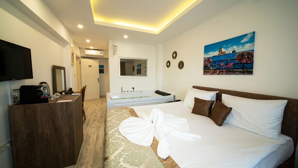 Una habitaci ón de hotel con cama, escritorio, televisión y baño.