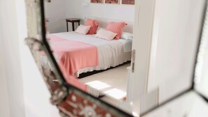 Une chambre à coucher avec un lit, des oreillers et une table de chevet.
