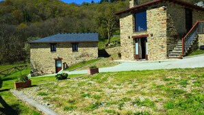 Une maison en pierre avec un petit bâtiment attenant, un escalier et une allée pavée.