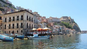 Une ville côtière dotée de bâtiments historiques, d’un front de mer dégagé et de bateaux amarrés.