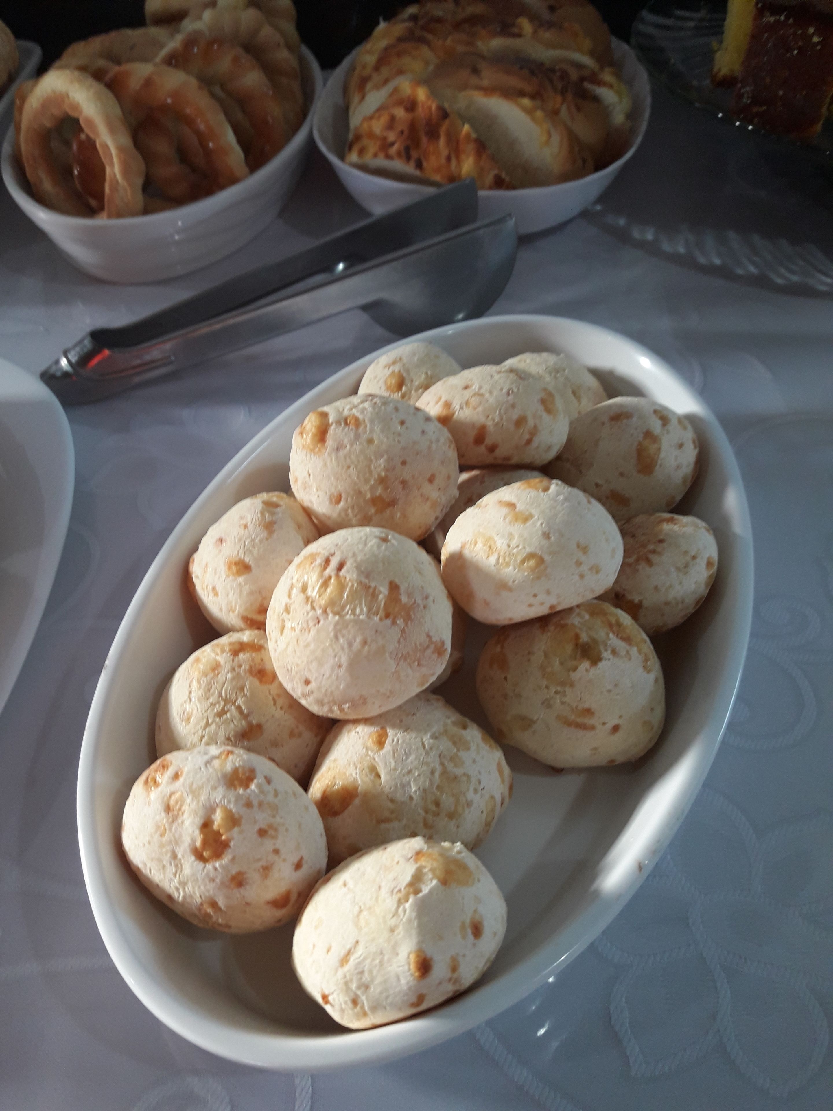A white bowl filled with small, round, white bread-like items.