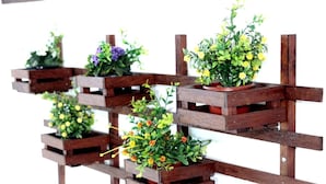Un support à plantes en bois muni de plusieurs pots.