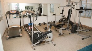 A gym with cardio machines, weightlifting equipment, and a mirror wall. - Sea Shell Residence (Dhaka)