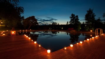 Una piscina al aire libre, sombrillas, sillones reclinables de piscina