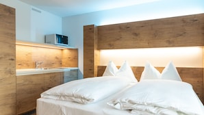 A modern bedroom with a wooden headboard, a built-in TV, and a bedside table. - Trip Inn Jet Hotel Zürich Airport (Ruemlang)