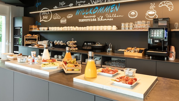 A breakfast bar with a variety of food items and a coffee machine. - Trip Inn Jet Hotel Zürich Airport (Ruemlang)