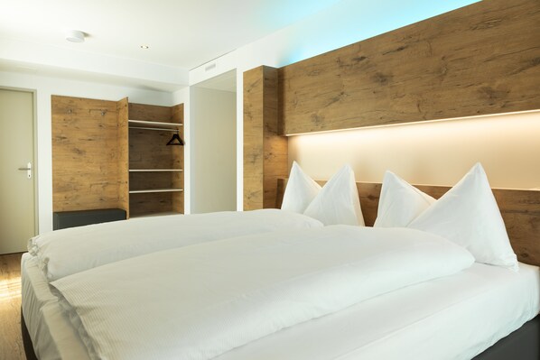 A modern bedroom with a large bed, wooden headboard, and built-in wardrobe. - Trip Inn Jet Hotel Zürich Airport (Ruemlang)