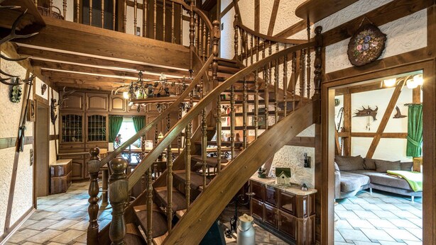 A traditional wooden staircase with a spiral design, leading to a lofted area with exposed beams and a rustic aesthetic. - Ferienhaus Stift Ennenbach (Ruppichteroth)