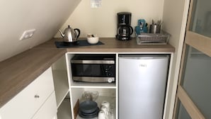 A compact kitchenette with a microwave, coffee maker, and a small refrigerator. - Chambre d'hôtes La Bourdonnaise (Bourdonne)