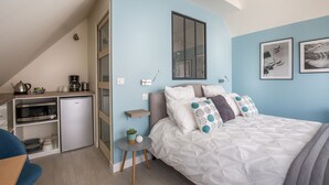 A compact bedroom with a bed, a small kitchenette, and a dining area. - Chambre d'hôtes La Bourdonnaise (Bourdonne)