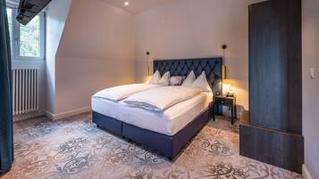 Un dormitorio con una cama grande, un radiador, una mesita de noche y un armario.