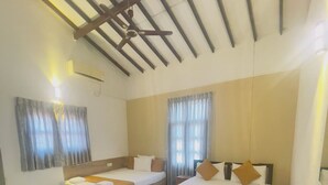 A hotel room with two beds, a ceiling fan, and a large window with curtains. - Chrish Residence (Negombo)